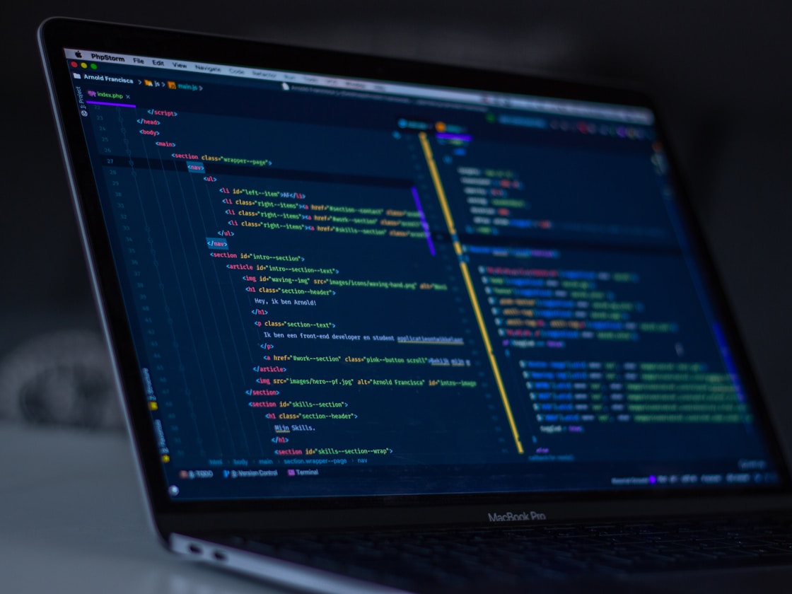 Software developer writing code on laptop